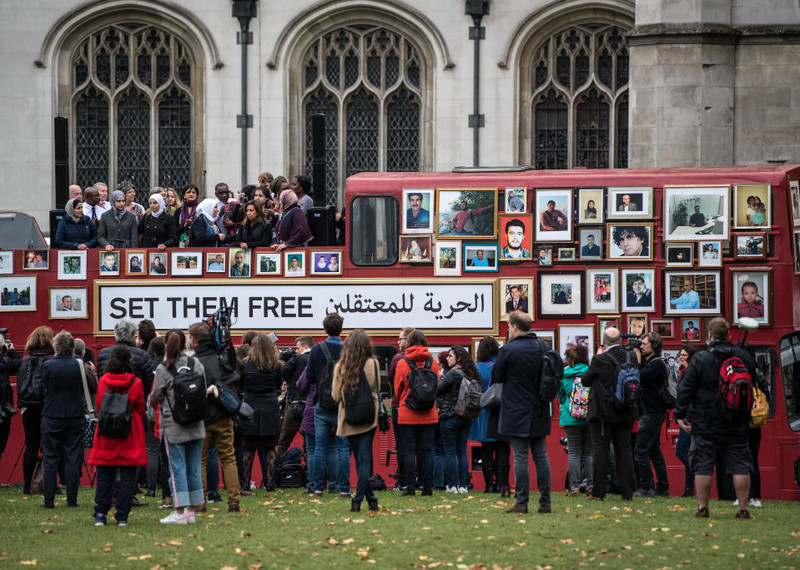 Ação de protesto com barraca vermelha e fotos de prisioneiros.