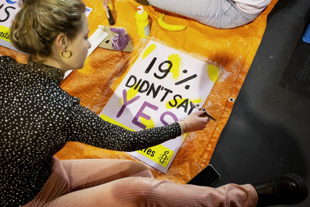 Pessoa a pintar um cartaz com a frase 19% DIDN'T SAY YES.