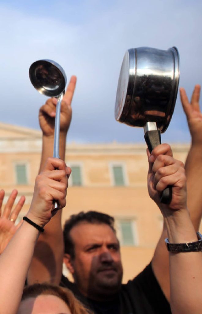Pessoas a protestar com utensílios de cozinha.
