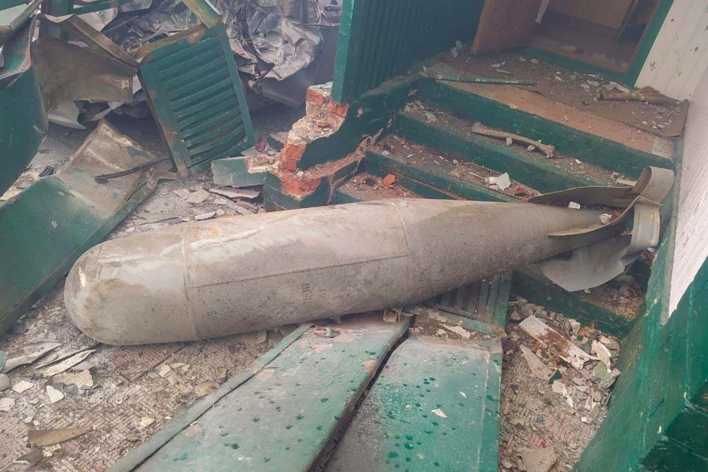 Bomba de grande porte no chão de um edifício danificado.
