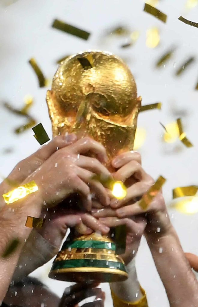 Troféu da Copa do Mundo sendo erguido entre confetes.