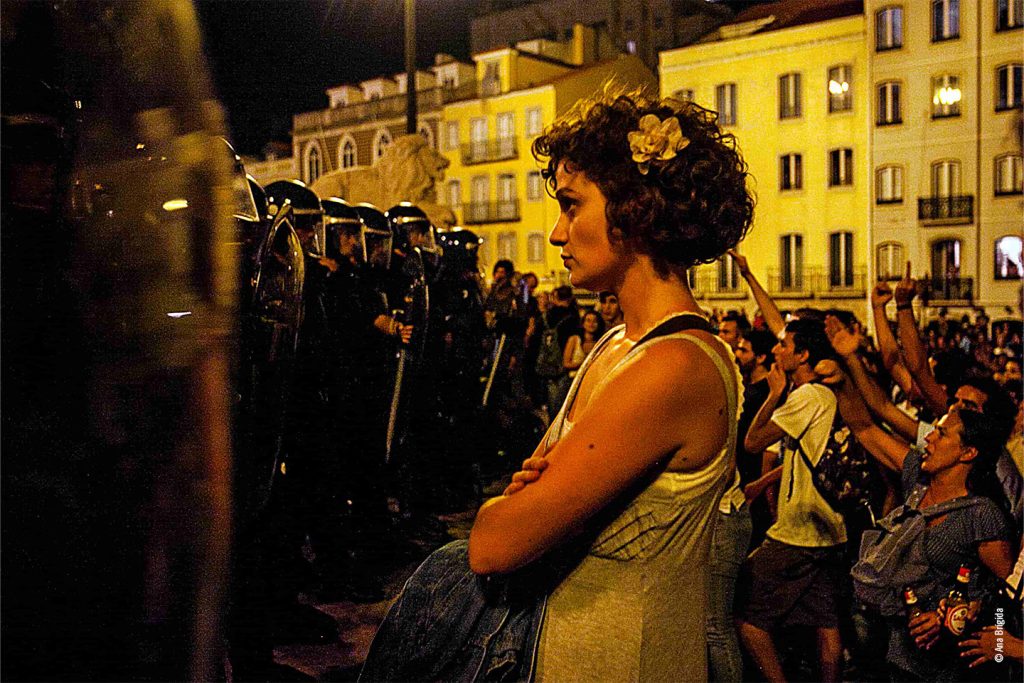 Protesto com barricadas de polícia e manifestantes.