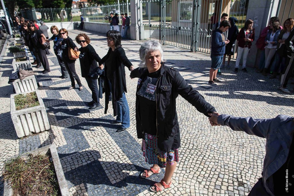 Protesto com pessoas de mãos dadas.