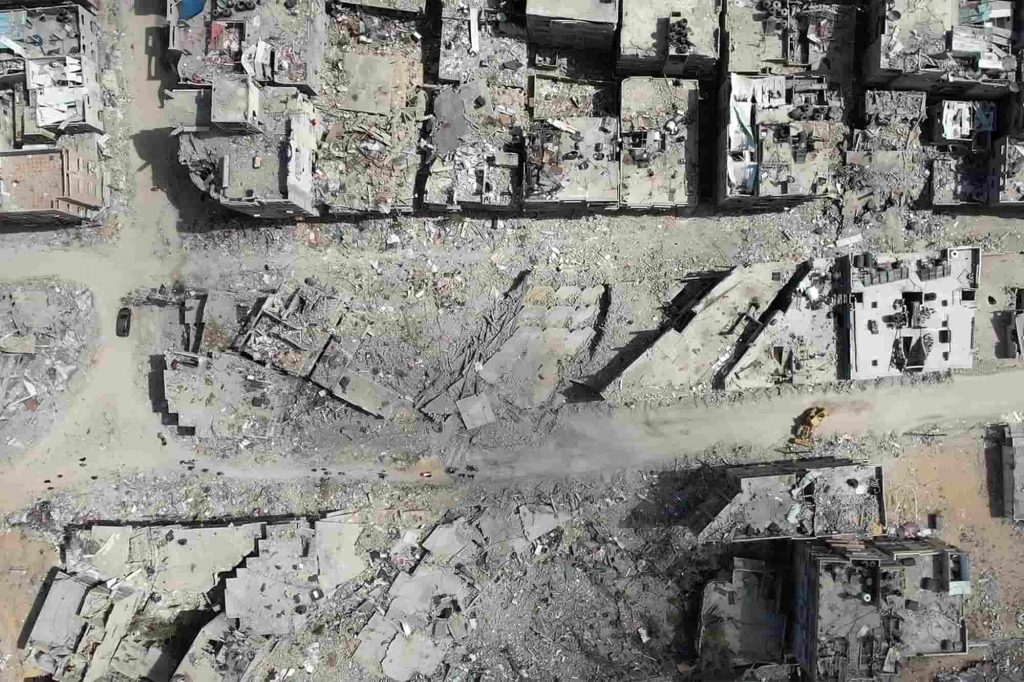 Este vídeo captado pela AFPTV mostra uma vista aérea de uma escavadora a limpar os escombros de edifícios destruídos em Khan Yunis, no sul da Faixa de Gaza, a 22 de abril de 2024, durante o conflito em curso no território palestiniano entre Israel e o grupo militante Hamas. Israel retirou as suas forças terrestres de Khan Yunis a 7 de abril, depois de ter realizado o que chamou de “operação precisa e limitada” no Complexo Médico Nasser, um dos maiores hospitais do território palestiniano.. Fotografia de -/AFPTV/AFP via Getty Images