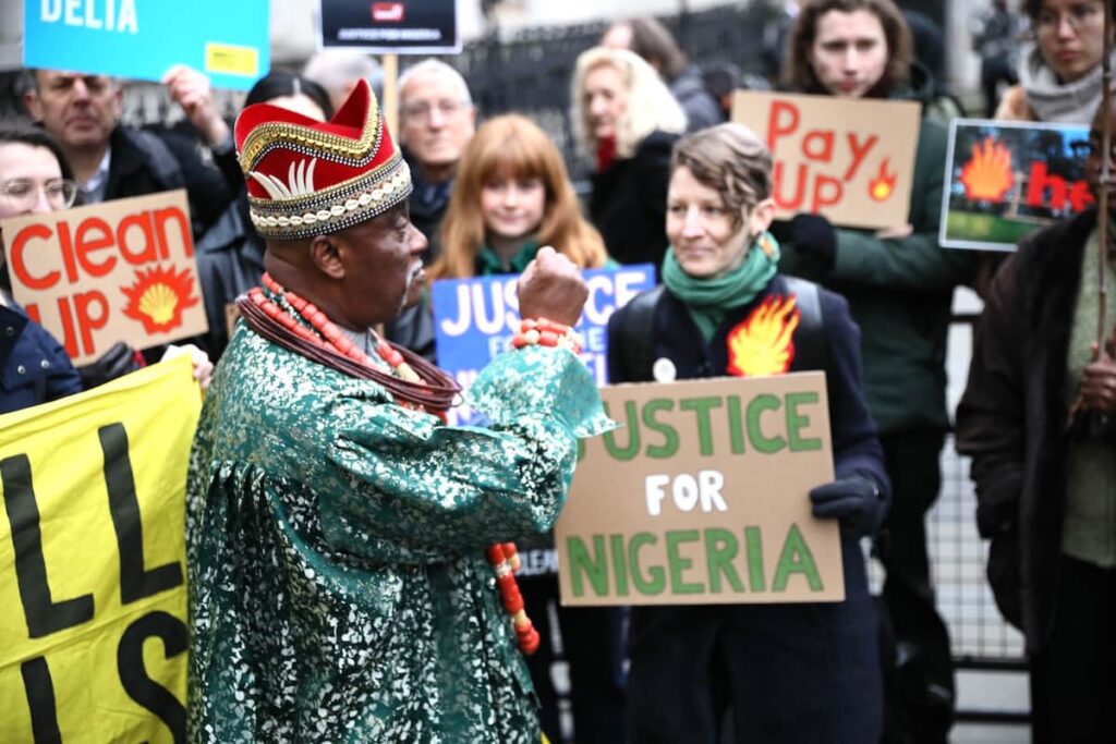 Ativistas e oradores – incluindo o Rei Okabi da comunidade Ogale – pedem o fim da poluição do Delta do Níger pela Shell e uma indemnização em frente ao Tribunal Real de Justiça de Londres, no primeiro dia do julgamento das comunidades Ogale e Bille contra a Shell, a 13 de fevereiro de 2025. Foto © M-A Ventoura/Amnistia Internacional - Reino Unido
