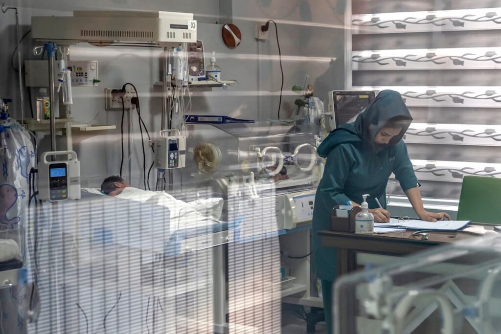 Esta fotografia tirada a 10 de dezembro de 2024 mostra uma parteira afegã a preparar um relatório na secção de pediatria de um hospital privado em Cabul. O líder supremo dos Talibãs está alegadamente por trás da proibição das mulheres estudarem obstetrícia e enfermagem em institutos de formação em todo o país, que já se encontra entre os piores do mundo em termos de mortalidade materna. Desde que o governo talibã proibiu as mulheres de frequentarem as universidades há dois anos, Shefajo tem ministrado formação médica no local de trabalho, incluindo obstetrícia e enfermagem. Foto de WAKIL KOHSAR/AFP via Getty Images.