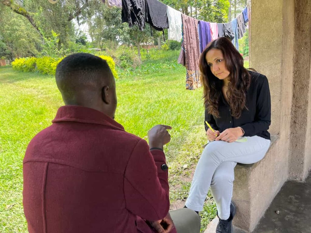 Rawya Rageh entrevista um sobrevivente dos ataques das ADF na RDC. Foto © Amnistia Internacional